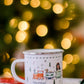 Mug with train design on a table in front of a Christmas tree with lights.
