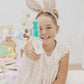 Young girl wearing bunny ears in a room with Easter decorations