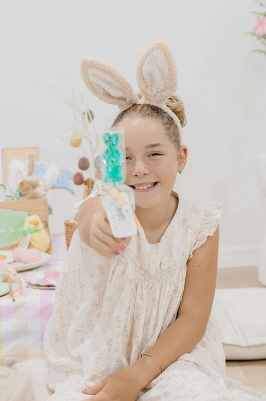 Young girl wearing bunny ears in a room with Easter decorations