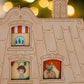 A close up view of the festive apartment advent calendar showing the windows with a little boy and a cute cat looking out
