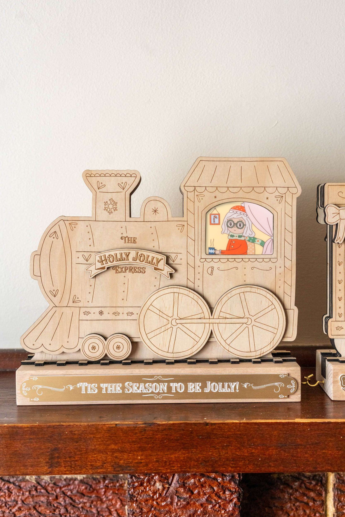 Wooden train decoration with 'Holly Jolly Express' on a shelf.