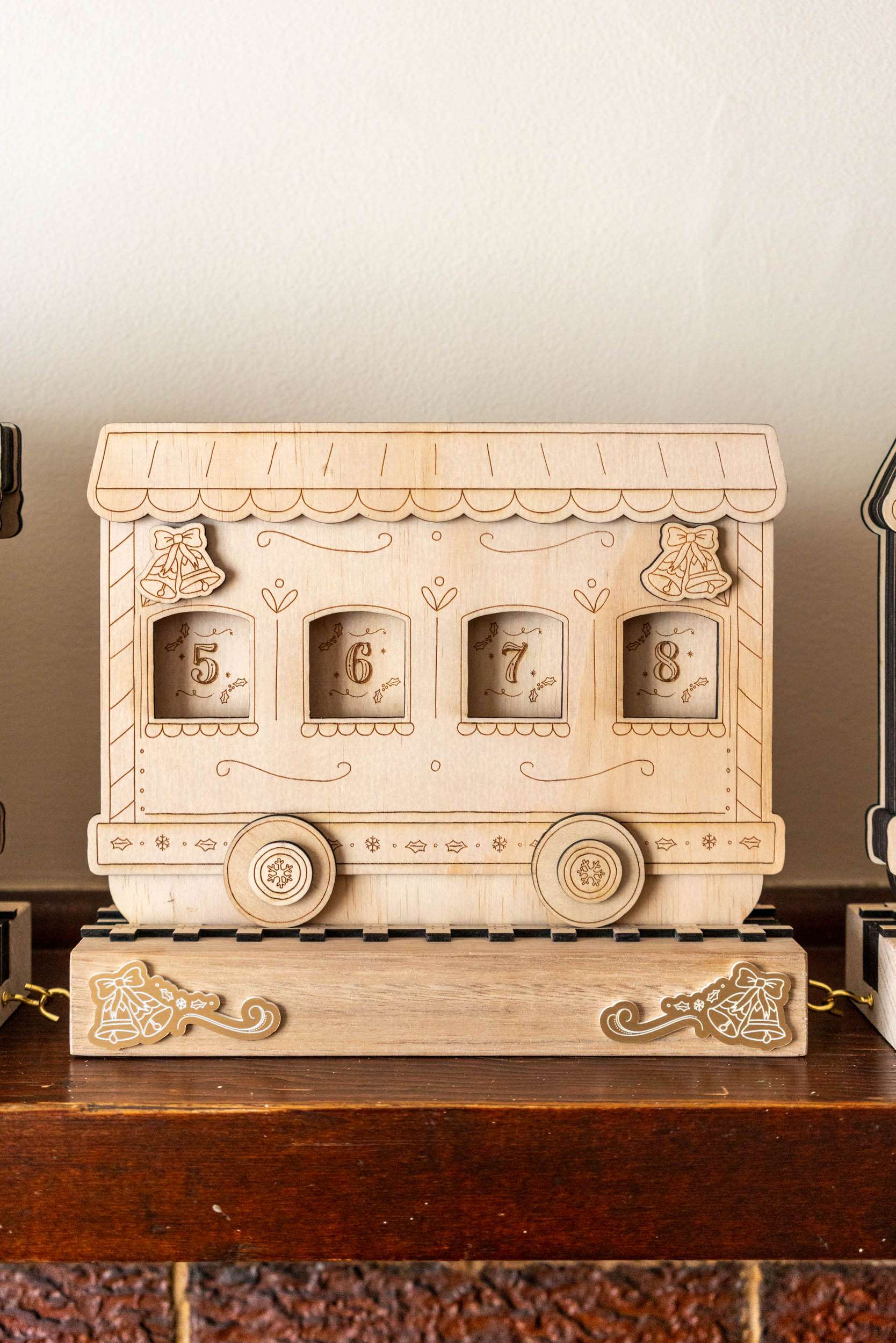 Wooden train advent calendar with decorative elements on a wooden surface.
