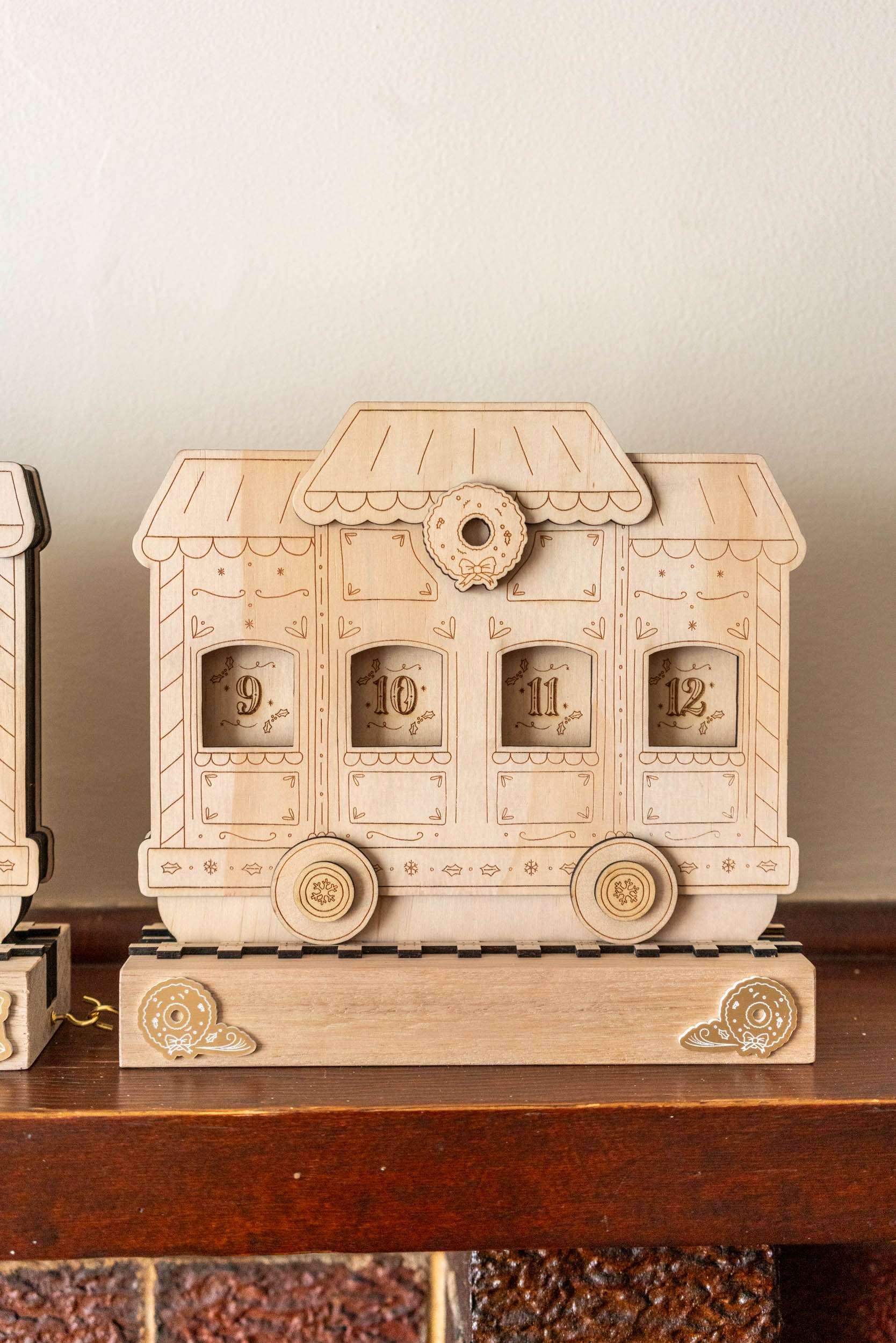 Wooden train advent calendar shaped like a train car on a wooden surface with a neutral background