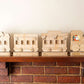 Wooden train advent calendar set on a brick mantle with a neutral background