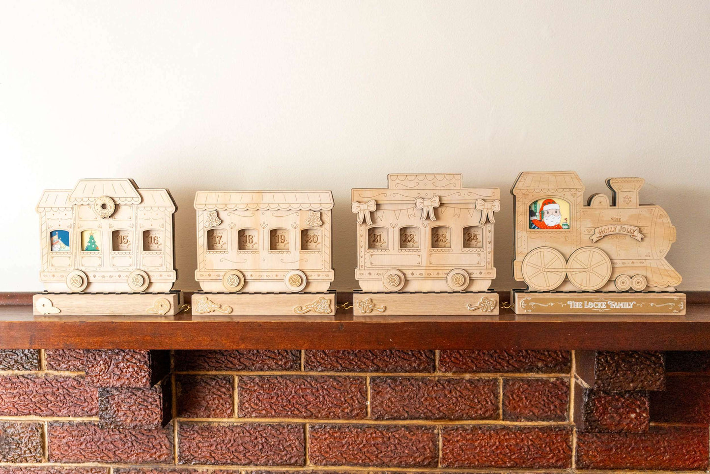 Wooden train advent calendar set on a brick mantle with a neutral background