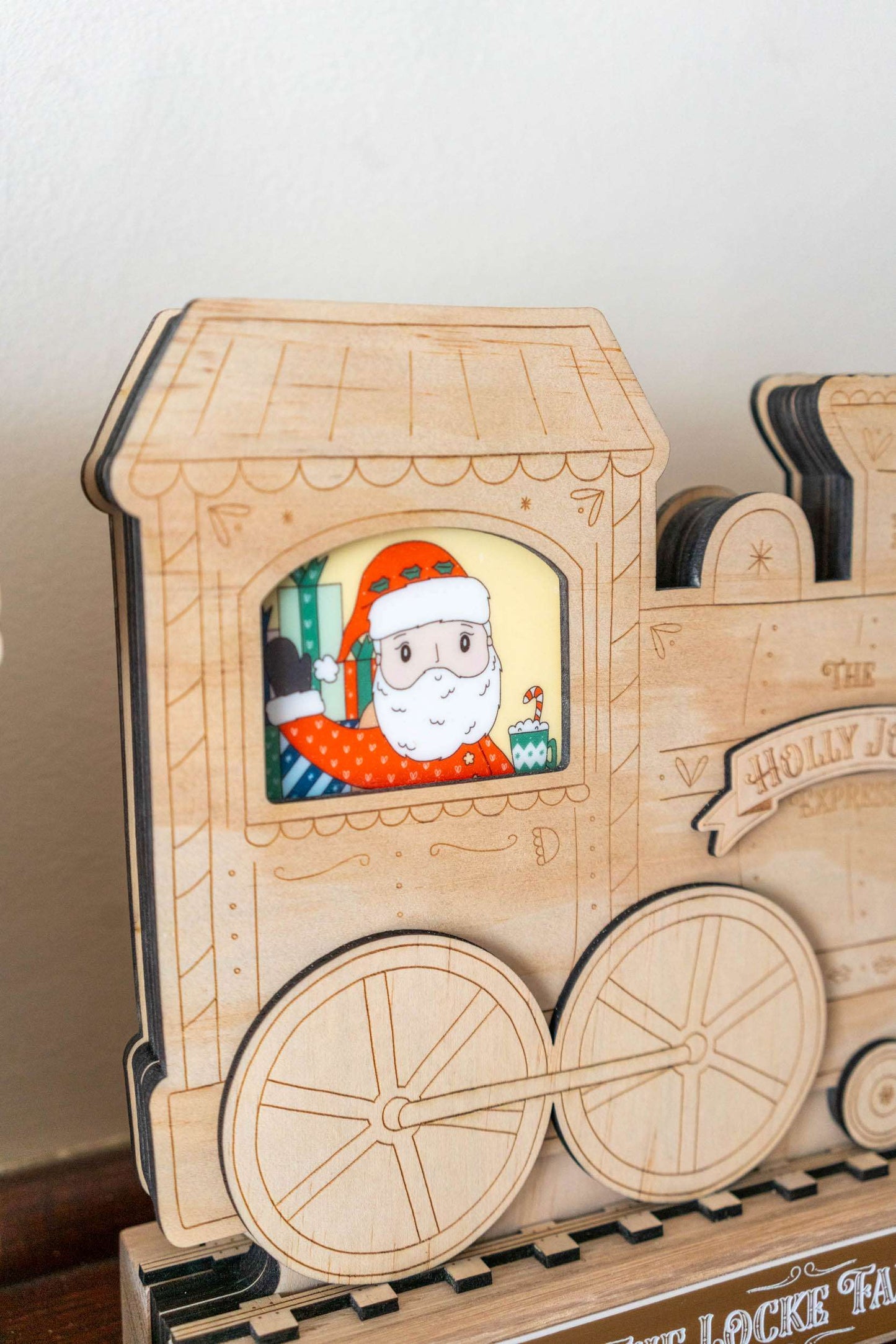 Wooden toy train with a Santa Claus figure inside a window