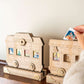 A wooden train advent calendar with a hand placing a tile in