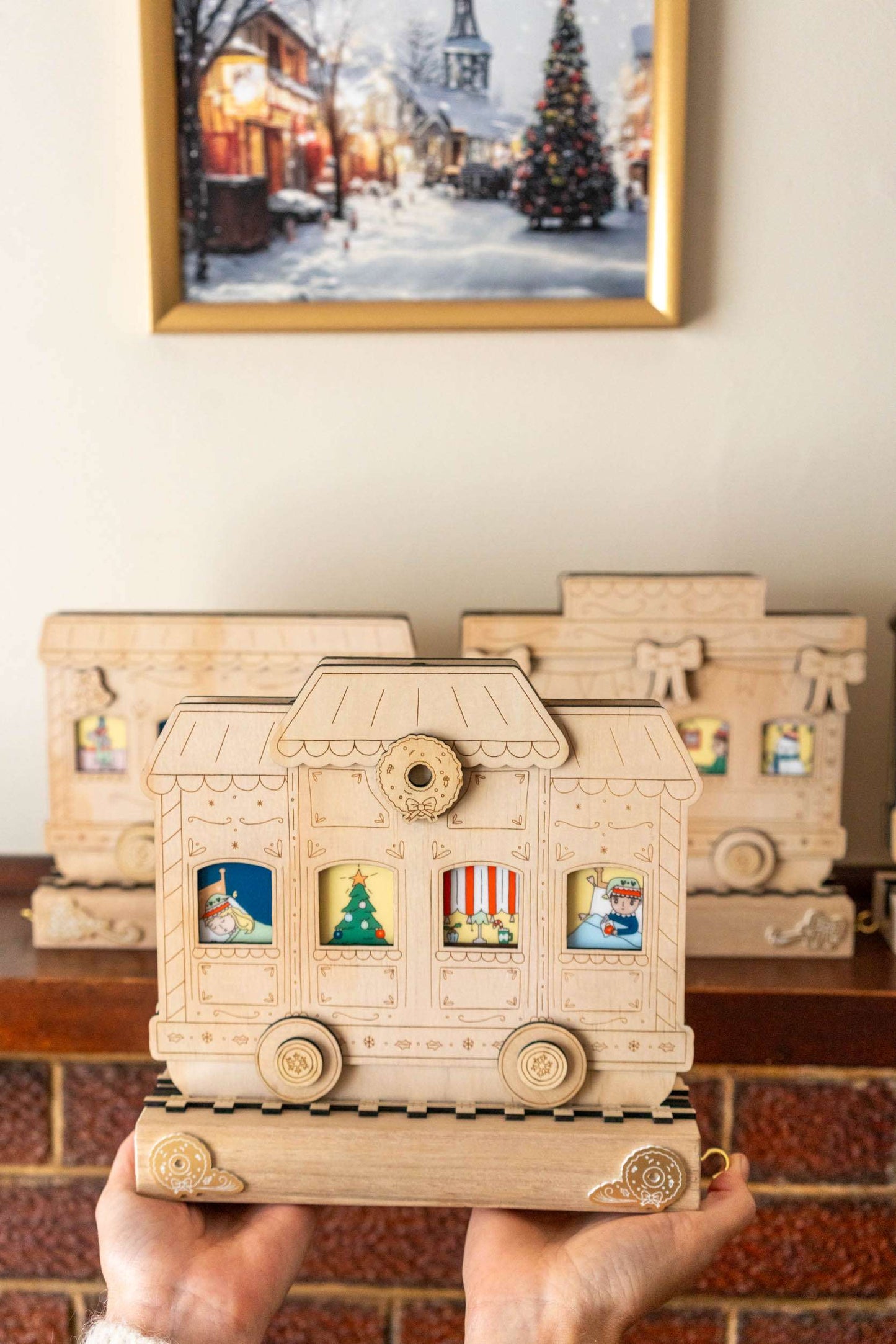 Wooden advent calendar held in front of a fireplace with Christmas decorations.